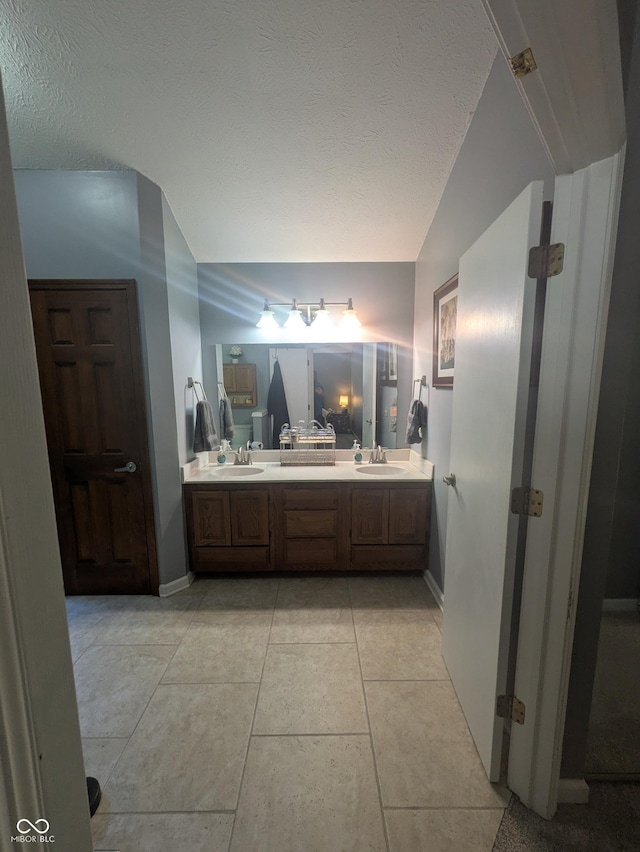 7327 Newbury Ct, Fishers, IN 46038 - bathroom with double vanity, lofted ceiling, and a textured ceiling