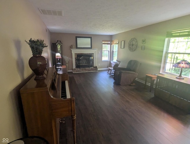 7327 Newbury Ct, Fishers, IN 46038 - living room with dark wood finished floors, a fireplace with raised hearth, and a textured ceiling