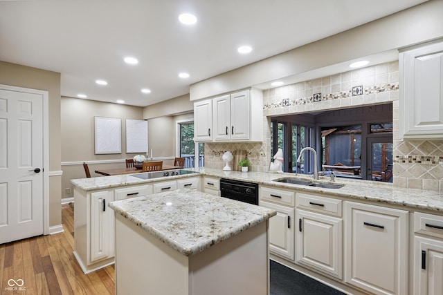 118 White Horse Ln, Fishers, IN 46038 - kitchen with black appliances, a peninsula, backsplash, a kitchen island, and light wood finished floors