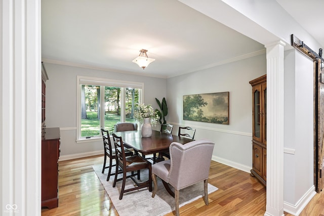 118 White Horse Ln, Fishers, IN 46038 - dining area featuring a barn door, light wood-style flooring, and ornamental molding