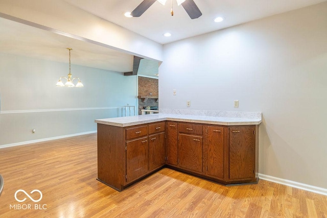1189 N County Road 475 E, Avon, IN 46123 - kitchen featuring light countertops, light wood finished floors, a peninsula, a ceiling fan, and a fireplace