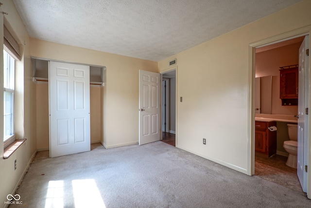 8809 Haddington Dr N, Indianapolis, IN 46256 - unfurnished bedroom with light colored carpet, a closet, a textured ceiling, and ensuite bath