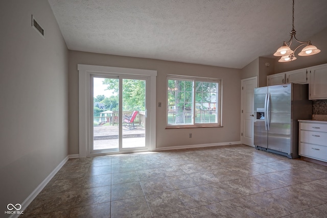 8809 Haddington Dr N, Indianapolis, IN 46256 - unfurnished dining area with healthy amount of natural light, a textured ceiling, a chandelier, and lofted ceiling