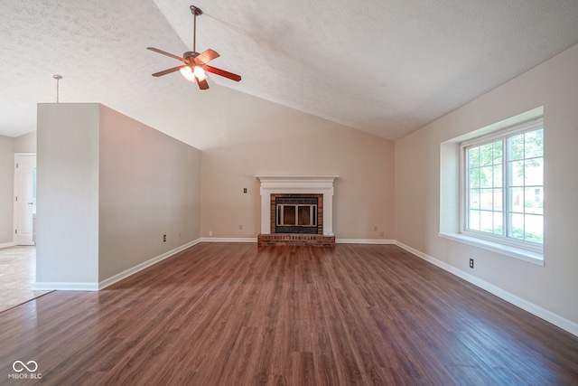 8809 Haddington Dr N, Indianapolis, IN 46256 - unfurnished living room featuring dark wood-type flooring, ceiling fan, a textured ceiling, vaulted ceiling, and a fireplace