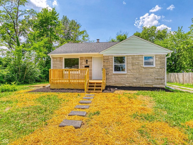 3748 N Olney St, Indianapolis, IN 46218 - view of front of house with stone siding, a deck, and roof with shingles
