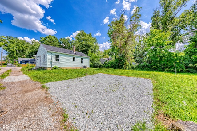 3748 N Olney St, Indianapolis, IN 46218 - view of side of property with a chimney and a yard