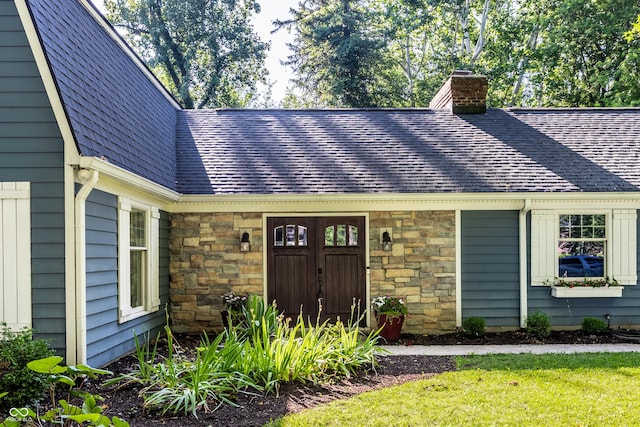 8627 Emerald Ln, Indianapolis, IN 46260 - property entrance with a chimney, roof with shingles, and stone siding