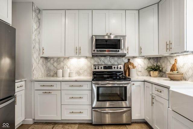 8627 Emerald Ln, Indianapolis, IN 46260 - kitchen with stainless steel appliances, light countertops, white cabinets, and decorative backsplash