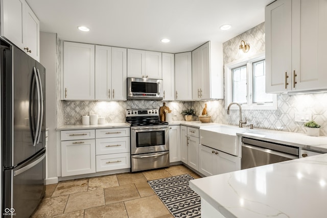 8627 Emerald Ln, Indianapolis, IN 46260 - kitchen with stainless steel appliances, white cabinets, light stone counters, decorative backsplash, and recessed lighting