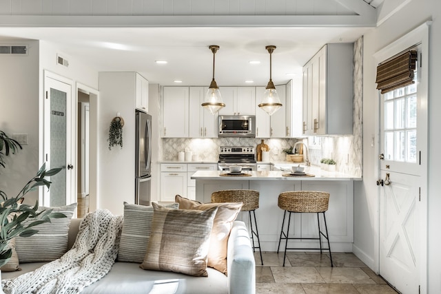 8627 Emerald Ln, Indianapolis, IN 46260 - kitchen with stainless steel appliances, backsplash, a peninsula, light countertops, and a breakfast bar