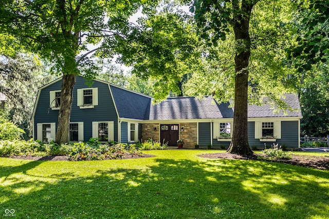 8627 Emerald Ln, Indianapolis, IN 46260 - dutch colonial with a gambrel roof, a front yard, and stone siding