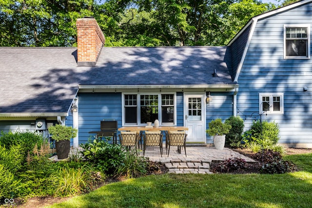 8627 Emerald Ln, Indianapolis, IN 46260 - rear view of property with a chimney, a patio area, a shingled roof, and a yard