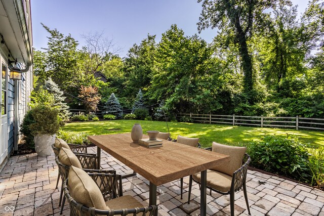 8627 Emerald Ln, Indianapolis, IN 46260 - fenced backyard featuring a patio, outdoor dining space, and view of scattered trees