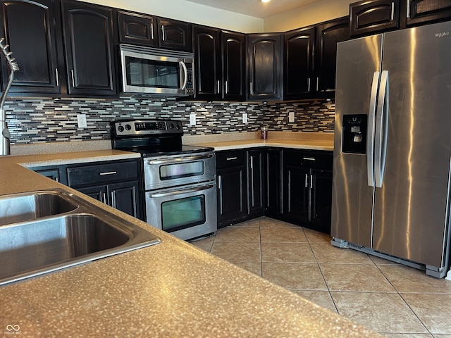 1646 N Nieman Dr, Greensburg, IN 47240 - kitchen featuring stainless steel appliances, dark cabinets, light tile patterned flooring, and backsplash