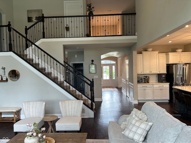12059 Chapelwood Dr, Fishers, IN 46037 - living area with a high ceiling, stairs, dark wood-style floors, arched walkways, and recessed lighting