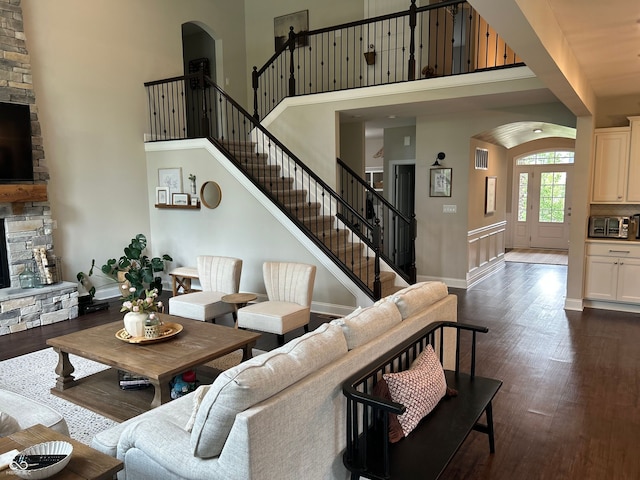 12059 Chapelwood Dr, Fishers, IN 46037 - living area with arched walkways, dark wood-style flooring, a high ceiling, a fireplace, and stairway