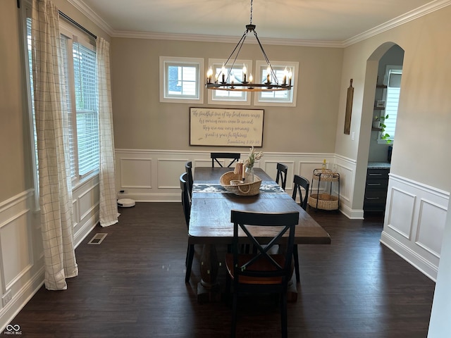 12059 Chapelwood Dr, Fishers, IN 46037 - dining space featuring arched walkways, a decorative wall, a chandelier, dark wood finished floors, and ornamental molding