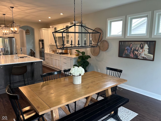 12059 Chapelwood Dr, Fishers, IN 46037 - dining space with a chandelier, dark wood-type flooring, arched walkways, and recessed lighting