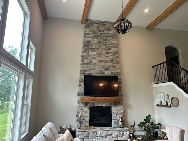 12059 Chapelwood Dr, Fishers, IN 46037 - living area featuring a towering ceiling, beam ceiling, a fireplace, a chandelier, and arched walkways