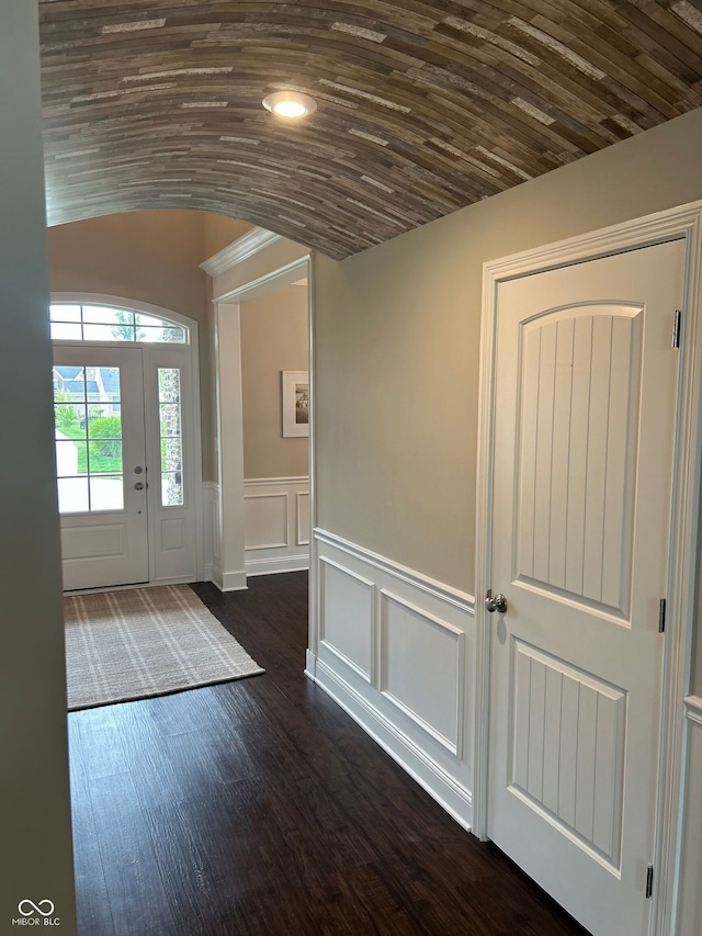 12059 Chapelwood Dr, Fishers, IN 46037 - entryway featuring dark wood-style floors, lofted ceiling, arched walkways, and wainscoting