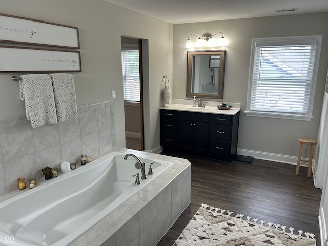12059 Chapelwood Dr, Fishers, IN 46037 - bathroom with vanity, a garden tub, and wood finished floors