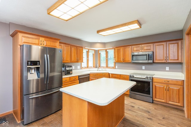 9437 N County Road 225 E, Pittsboro, IN 46167 - kitchen featuring appliances with stainless steel finishes, light countertops, light wood finished floors, a center island, and brown cabinets