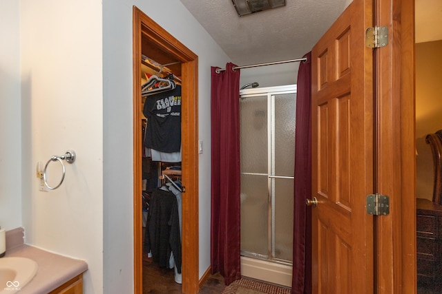 9437 N County Road 225 E, Pittsboro, IN 46167 - full bathroom with a shower stall, a walk in closet, vanity, and a textured ceiling