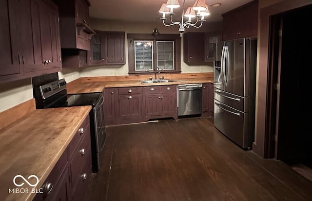 98 E Smithville Rd, Bloomington, IN 47401 - kitchen with appliances with stainless steel finishes, a chandelier, glass insert cabinets, dark wood finished floors, and wood counters