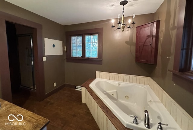 98 E Smithville Rd, Bloomington, IN 47401 - bathroom with a chandelier, a tub with jets, and wood finished floors