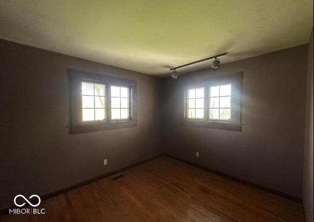 98 E Smithville Rd, Bloomington, IN 47401 - unfurnished room featuring healthy amount of natural light, dark wood finished floors, and rail lighting