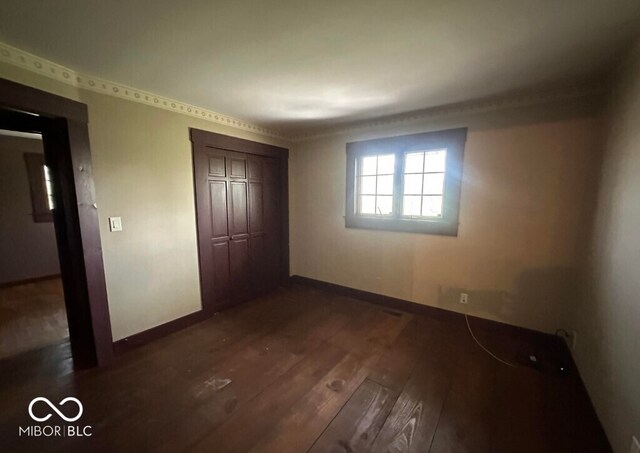 98 E Smithville Rd, Bloomington, IN 47401 - unfurnished bedroom with dark wood-type flooring and a closet