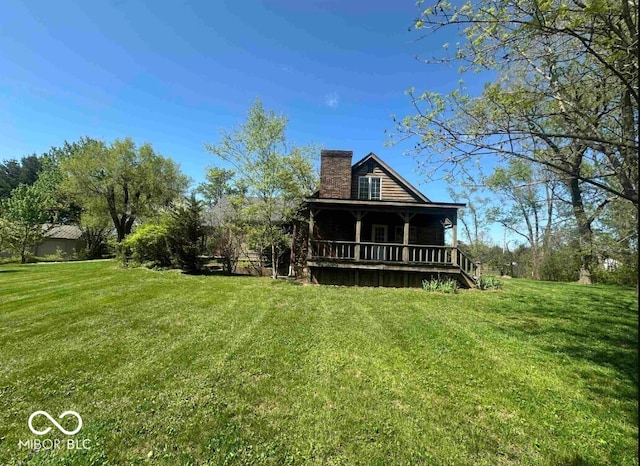 98 E Smithville Rd, Bloomington, IN 47401 - rear view of property with a chimney, a yard, and covered porch