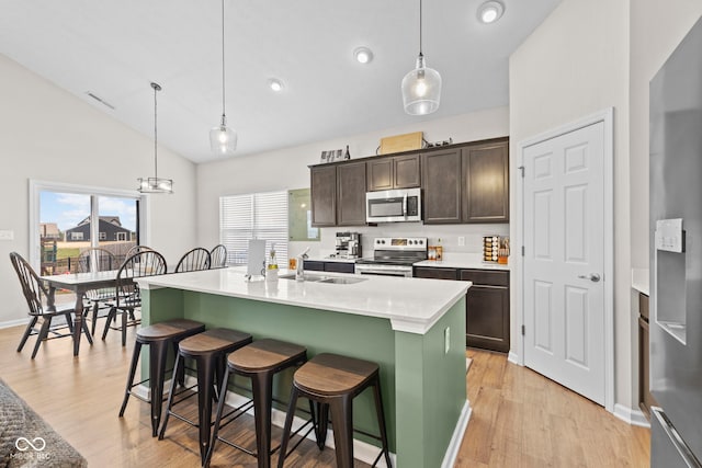 1448 Willow Tree Ln, Sheridan, IN 46069 - kitchen with stainless steel microwave, range with electric cooktop, dark brown cabinets, light wood-style flooring, and vaulted ceiling