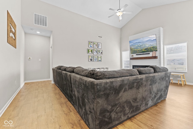 1448 Willow Tree Ln, Sheridan, IN 46069 - living area with light wood-type flooring, a ceiling fan, a fireplace, and high vaulted ceiling