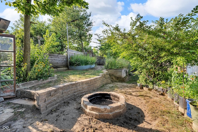 1058 Creekwood Ln, Franklin, IN 46131 - fenced backyard featuring a fire pit and a vegetable garden