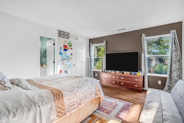 1058 Creekwood Ln, Franklin, IN 46131 - bedroom with multiple windows, wood finished floors, and ensuite bath