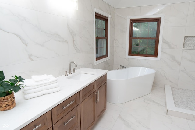 10630 Thorny Rdg Trce, Fishers, IN 46037 - bathroom with tile walls, marble finish flooring, a freestanding tub, and vanity