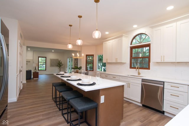 10630 Thorny Rdg Trce, Fishers, IN 46037 - kitchen with stainless steel appliances, white cabinetry, a breakfast bar, light wood-style floors, and recessed lighting