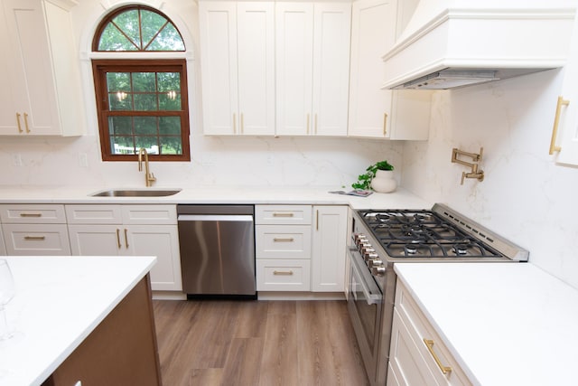 10630 Thorny Rdg Trce, Fishers, IN 46037 - kitchen with stainless steel appliances, premium range hood, light wood-style floors, and white cabinets