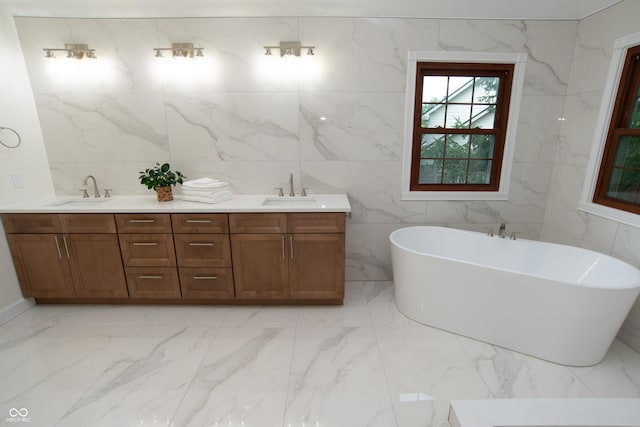 10630 Thorny Rdg Trce, Fishers, IN 46037 - bathroom with marble tiled floors, tile walls, a freestanding bath, and double vanity