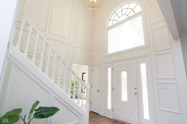 10630 Thorny Rdg Trce, Fishers, IN 46037 - entryway with a towering ceiling, stairway, a decorative wall, wood finished floors, and a chandelier