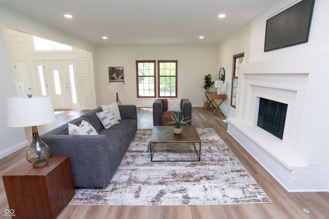 10630 Thorny Rdg Trce, Fishers, IN 46037 - living room featuring wood finished floors, recessed lighting, a fireplace with raised hearth, and ornamental molding