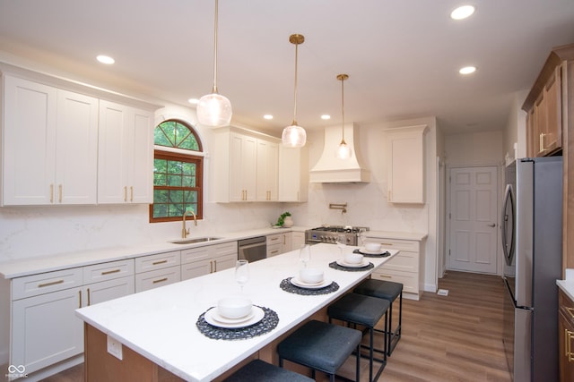 10630 Thorny Rdg Trce, Fishers, IN 46037 - kitchen with appliances with stainless steel finishes, recessed lighting, a breakfast bar area, tasteful backsplash, and custom exhaust hood