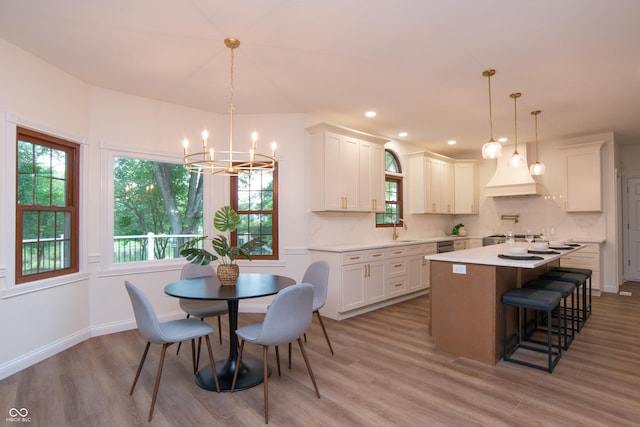 10630 Thorny Rdg Trce, Fishers, IN 46037 - kitchen with a chandelier, light wood finished floors, light countertops, a breakfast bar area, and white cabinets