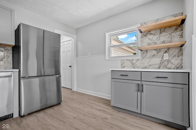 184 N Post Rd, Indianapolis, IN 46219 - kitchen with appliances with stainless steel finishes, gray cabinetry, light wood-type flooring, backsplash, and wainscoting