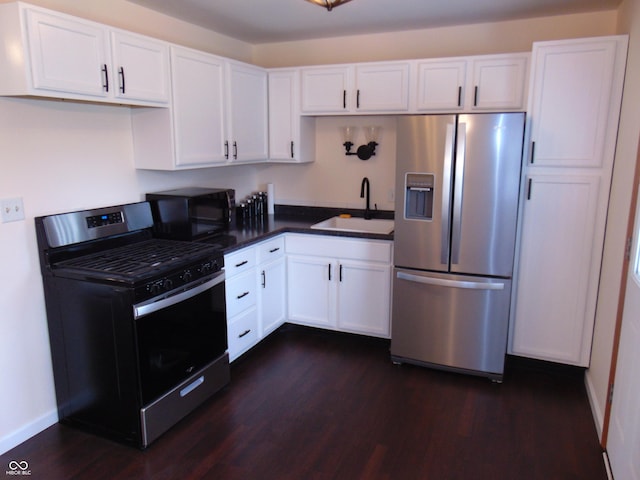 4546 Laclede St, Indianapolis, IN 46221 - kitchen with appliances with stainless steel finishes, white cabinets, dark wood-style flooring, and dark countertops