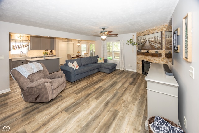 14126 Stonewood Pl, Fishers, IN 46037 - living room featuring ceiling fan, wood finished floors, a fireplace, and a textured ceiling