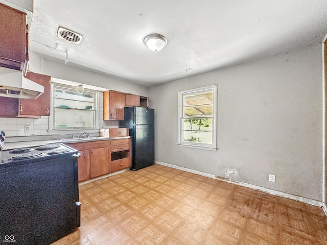 3505 N Emerson Ave, Indianapolis, IN 46218 - kitchen with black appliances, brown cabinetry, backsplash, and light countertops