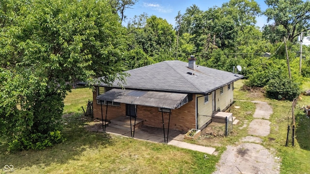 3505 N Emerson Ave, Indianapolis, IN 46218 - view of side of home with a chimney, roof with shingles, and a yard
