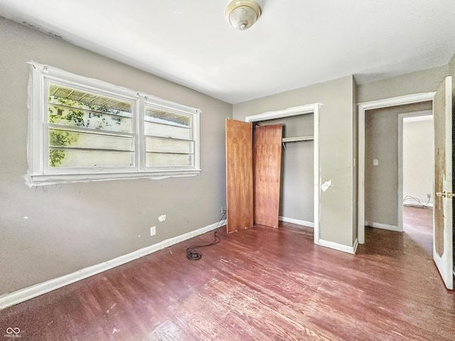 3505 N Emerson Ave, Indianapolis, IN 46218 - unfurnished bedroom featuring multiple windows, wood finished floors, and a closet